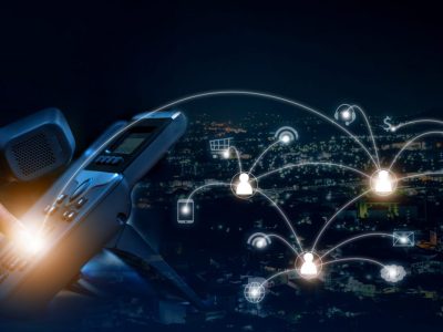 Concept of voip telecommunication, business woman pick up the handset and press the number button of ip telephone and connection line, services icon on night cityscape background